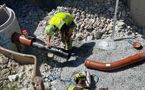 Installation of a PE to PVC transition on a wastewater project in Skien, Norway. The image shows the transition being installed between PE and PVC pipes at the construction site.