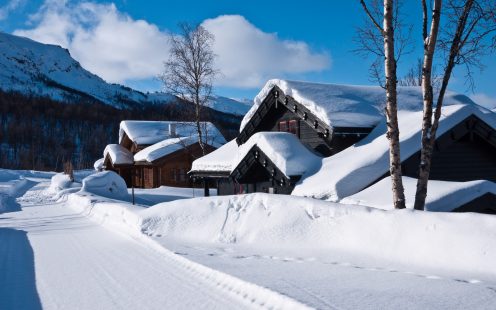 Snow covered norwegian mountain cottages at a sunny day at easter